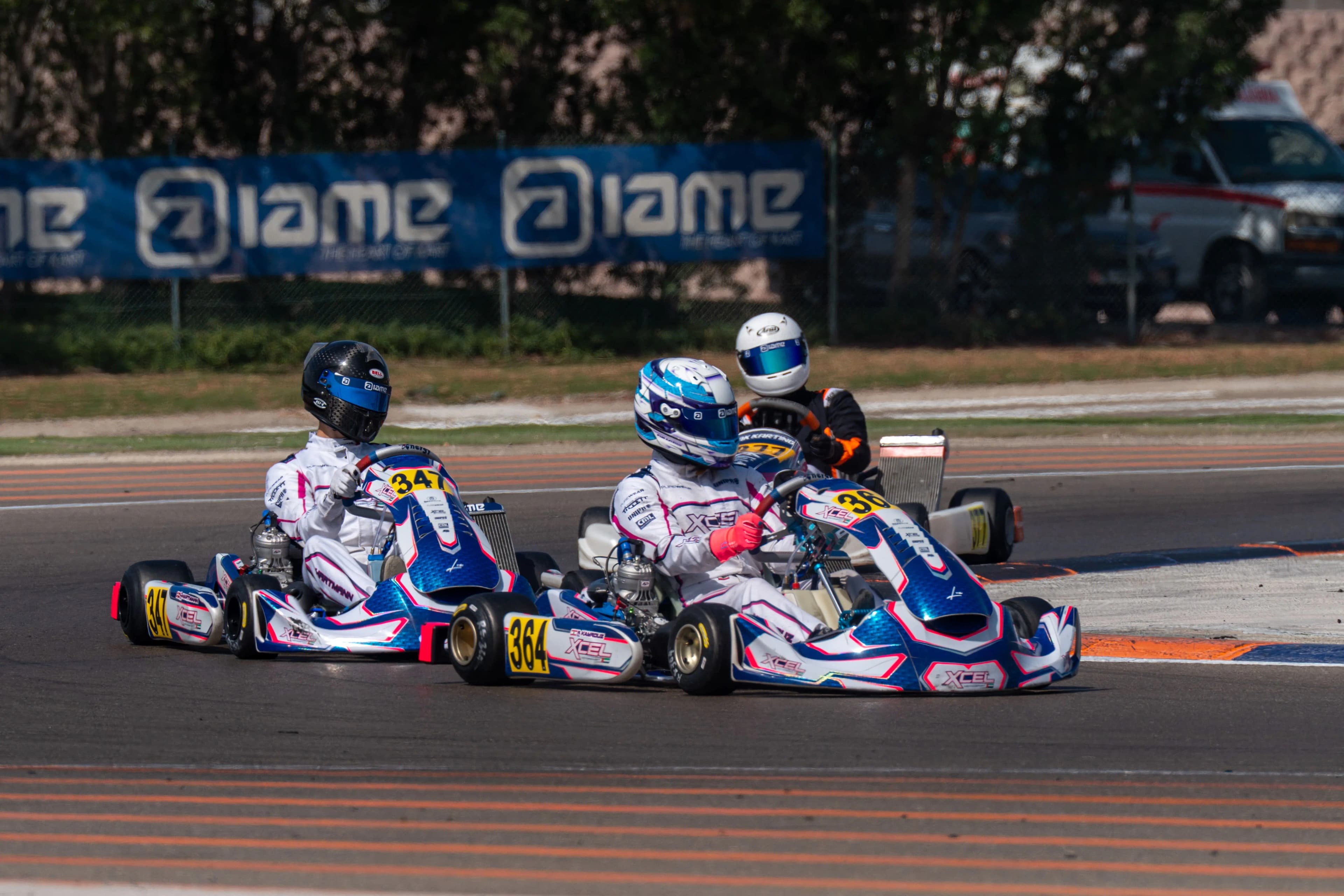 Two young drivers side by side into a corner