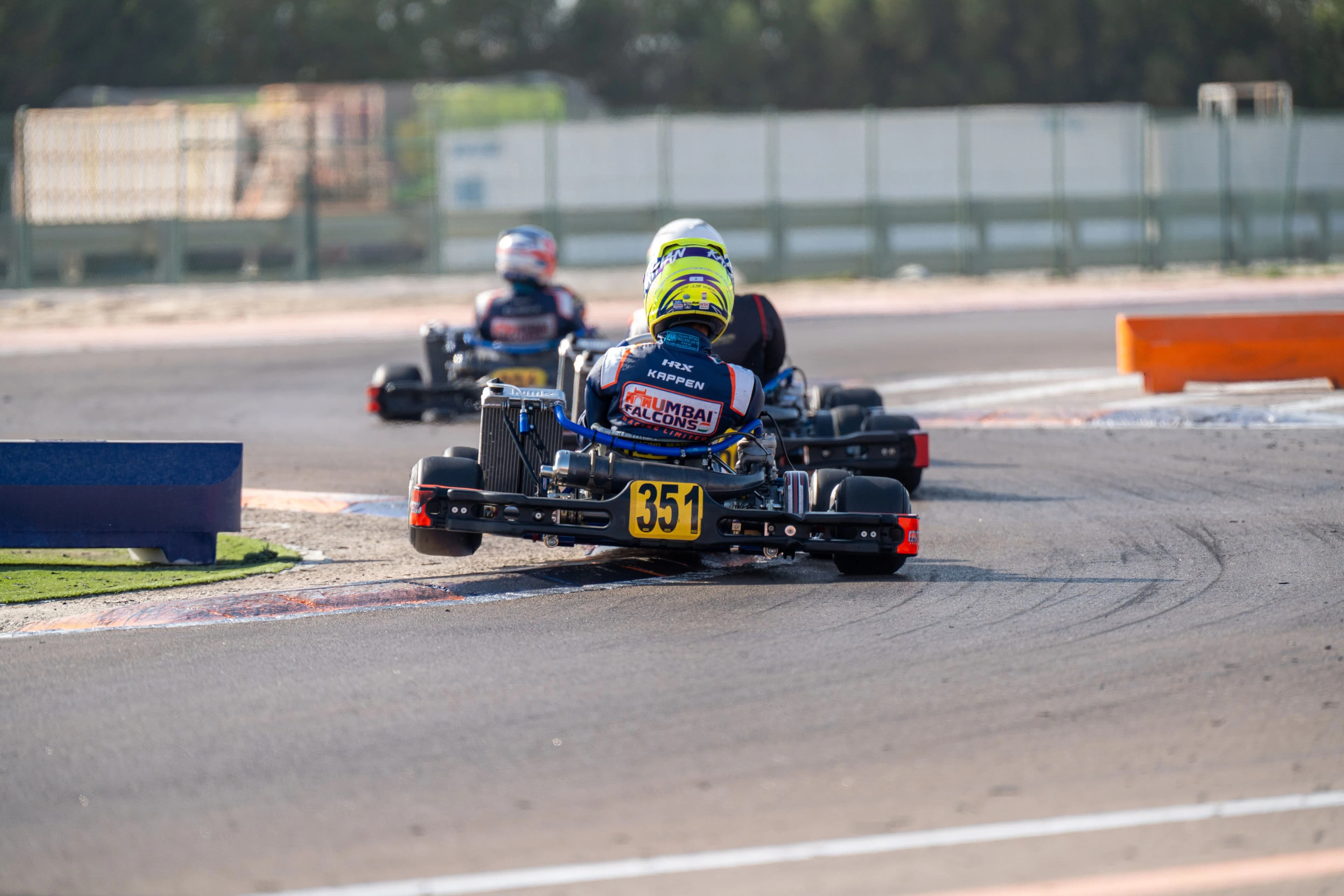 A pack of karts battling for position out of a bend