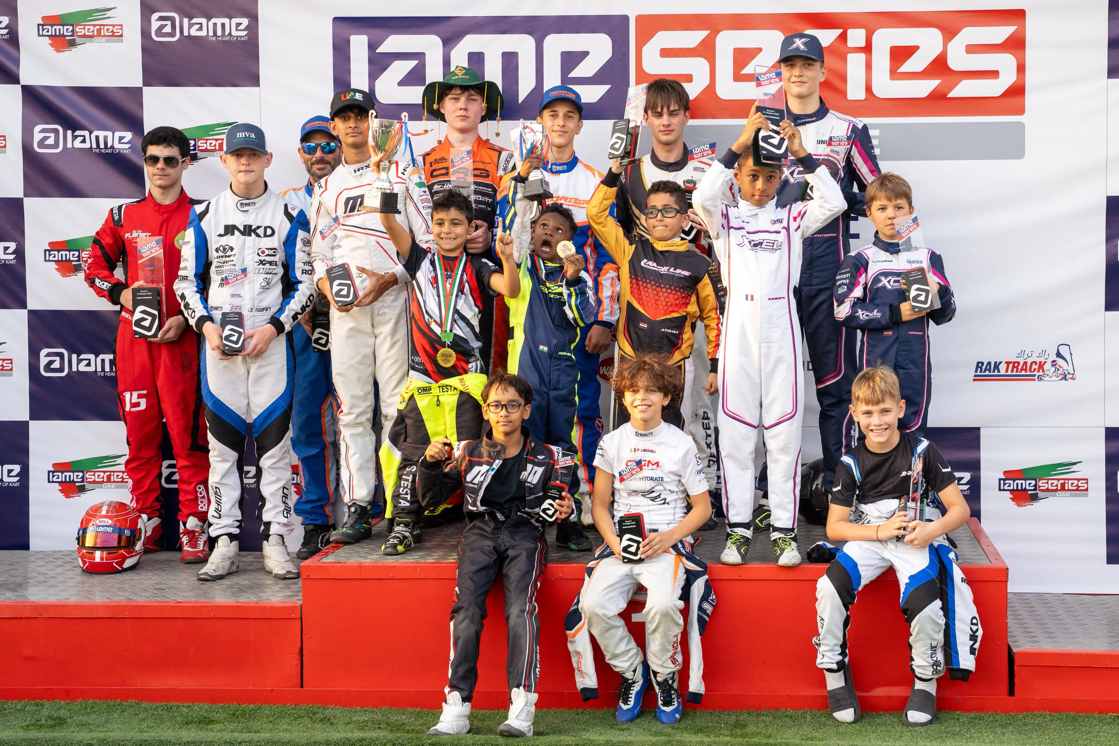Young drivers on the podium steps at IAME Series UAE